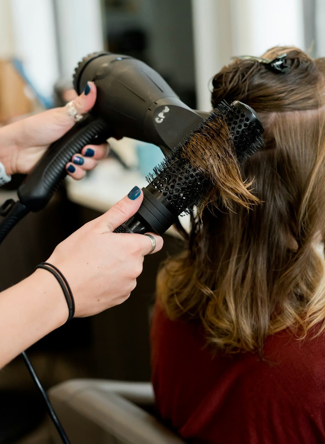 Stylist finishing a blow-dry at THE ASH unisex salon in Pimple Saudagar, Pune